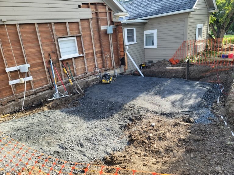 Excavated work area beside an existing house