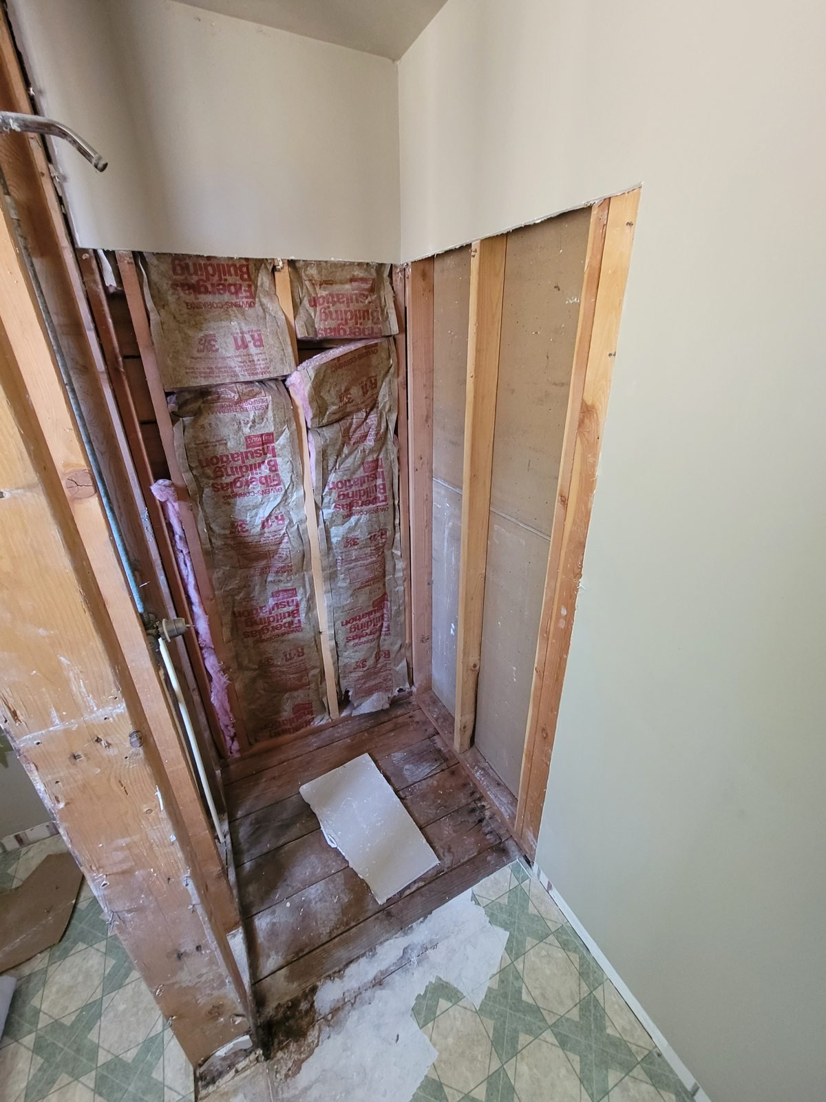 Opened wall with exposed framing and insulation during repair