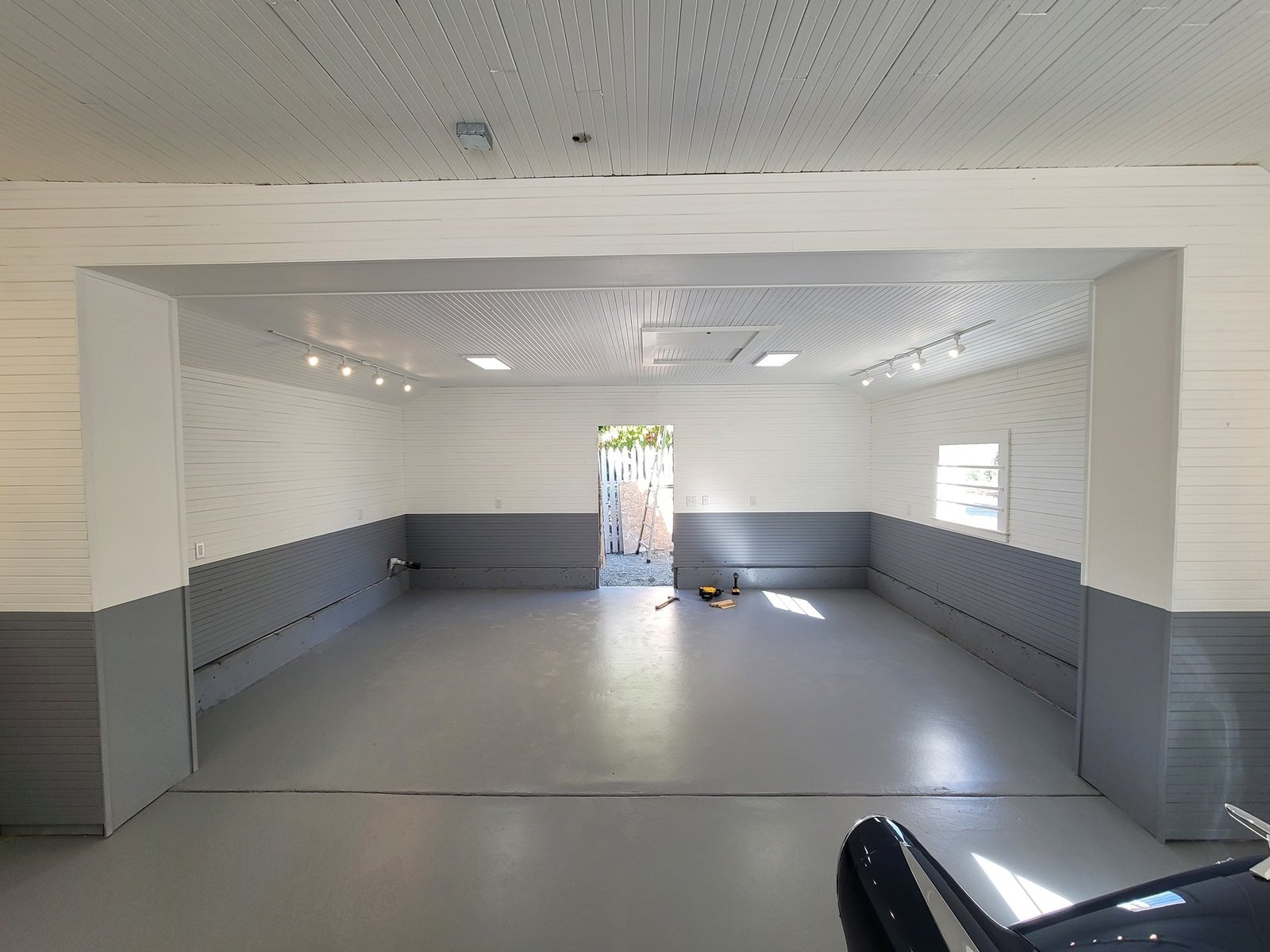 Open garage interior with gray lower walls and a finished floor