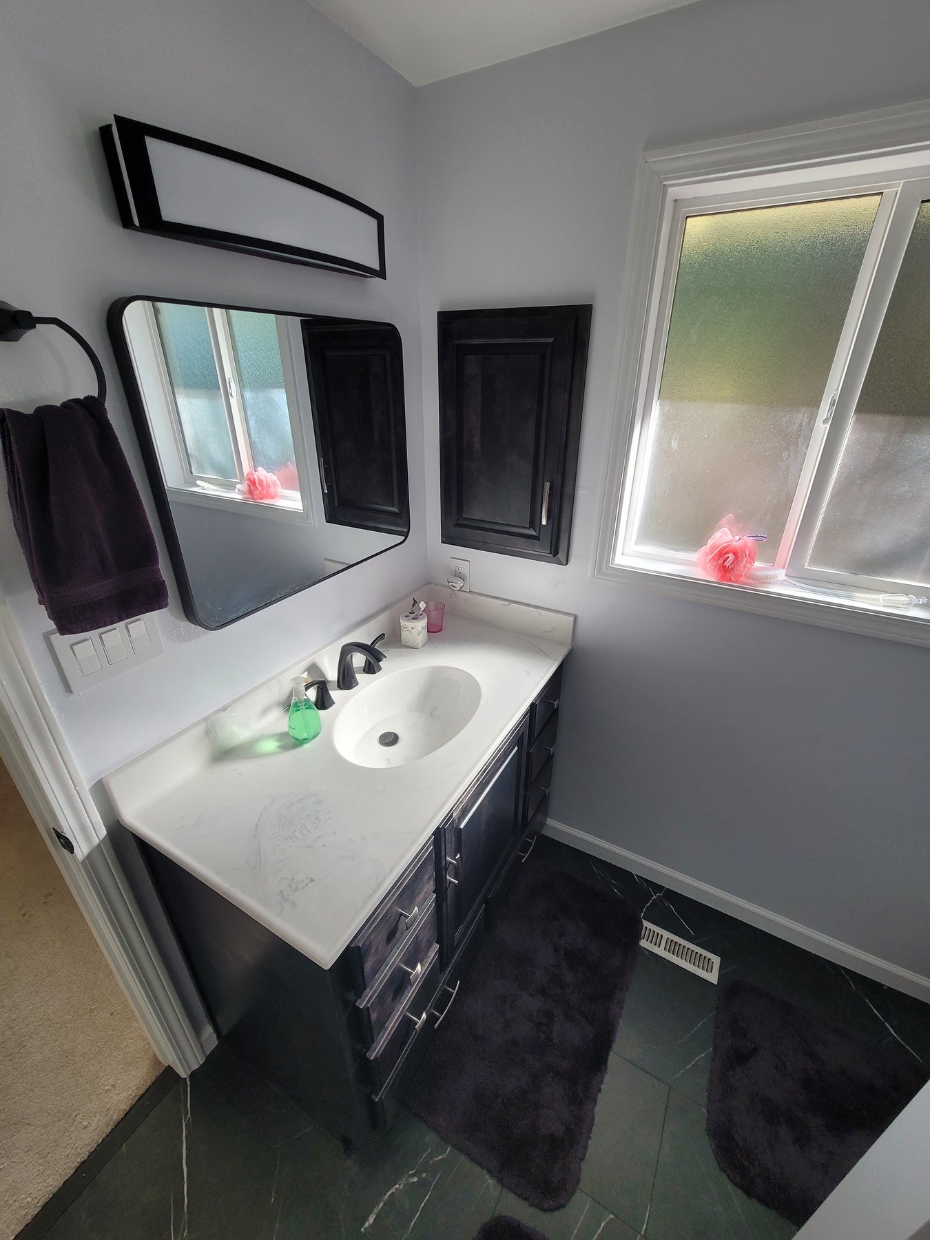 Bathroom vanity with mirror and black-framed wall cabinet