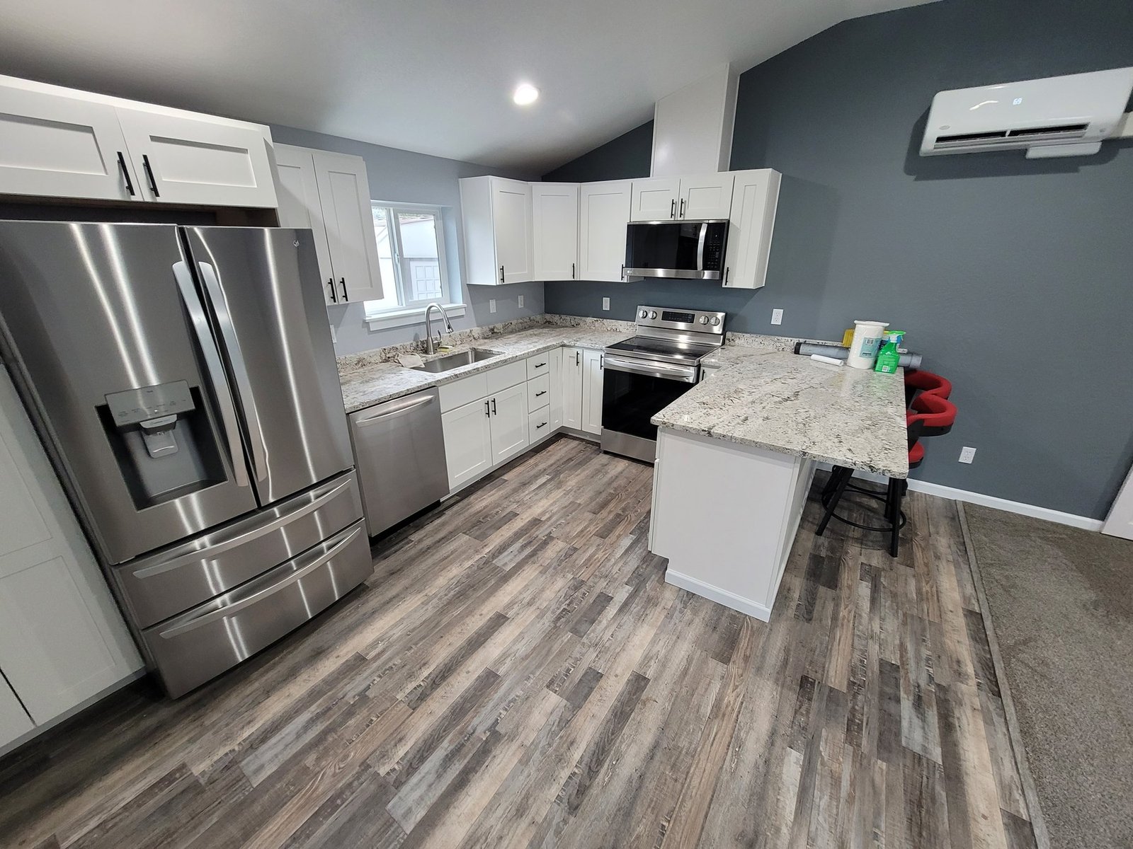 White kitchen with a peninsula and wood-look flooring