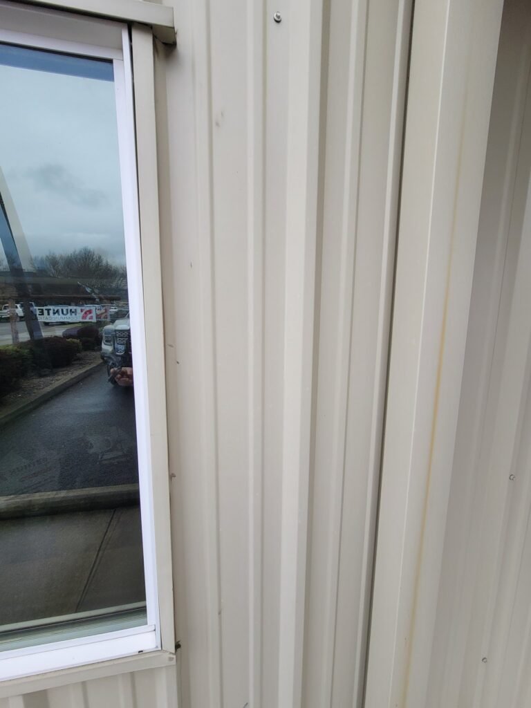Close view of window trim beside exterior siding