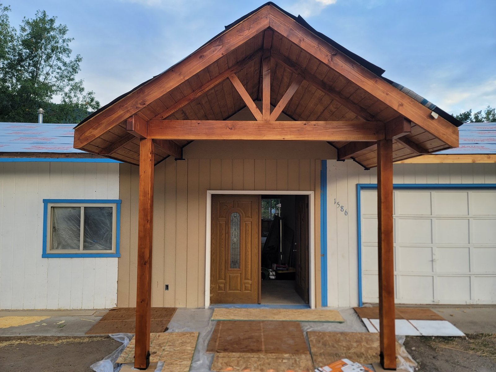 Timber gabled entry with a wood front door