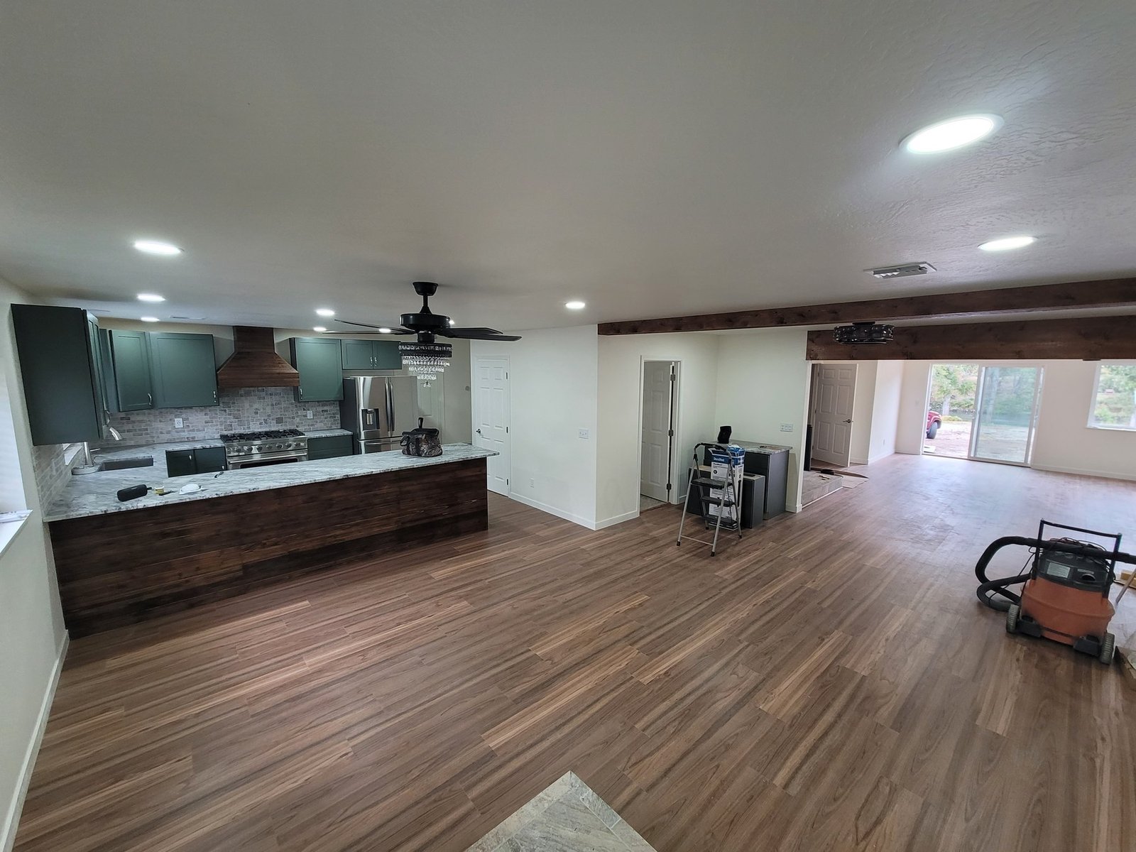 Open kitchen and living area with wood-look flooring