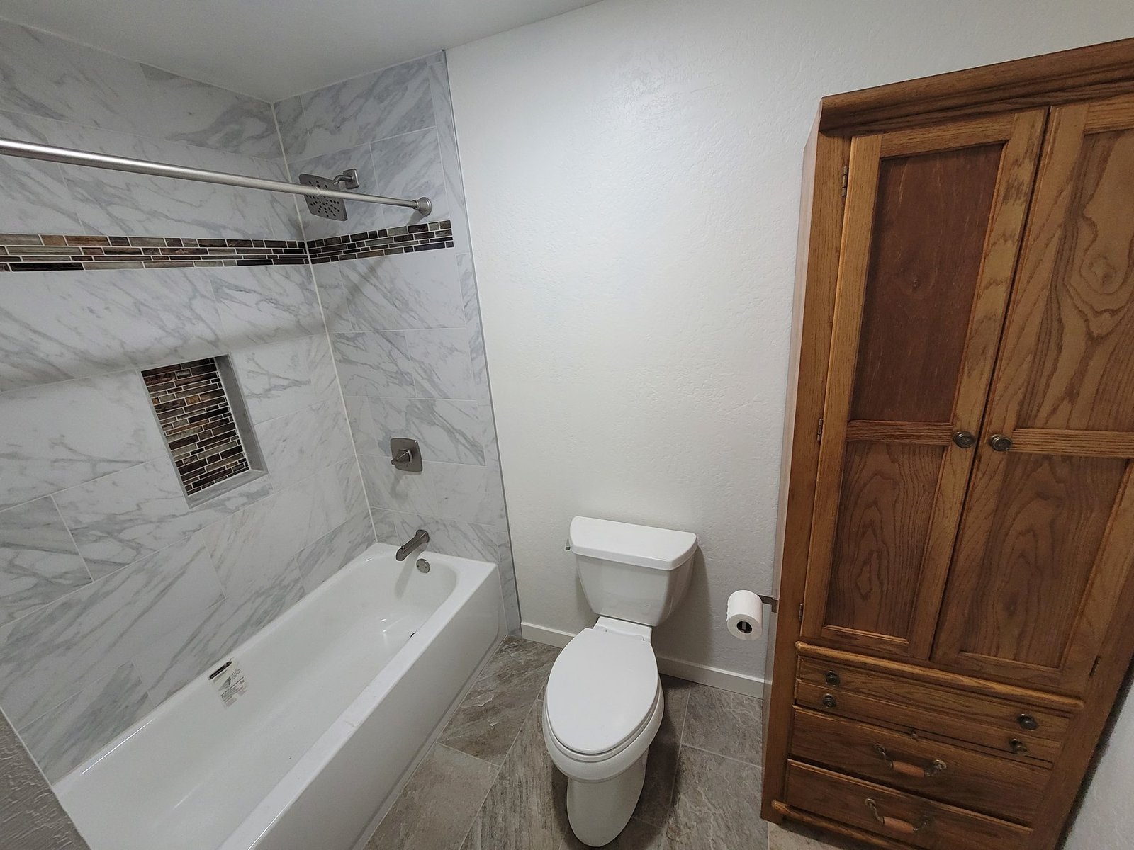 Bathroom with tiled tub surround and wood door