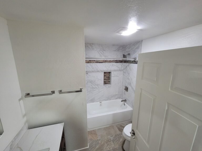 Bathroom with a white vanity counter and tiled tub surround