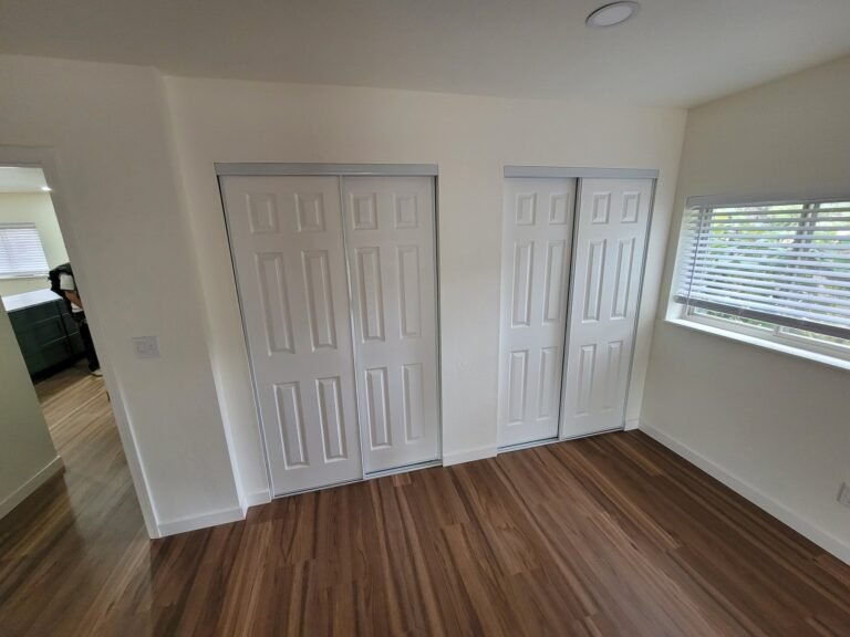 Wood-look bedroom flooring and white closet doors