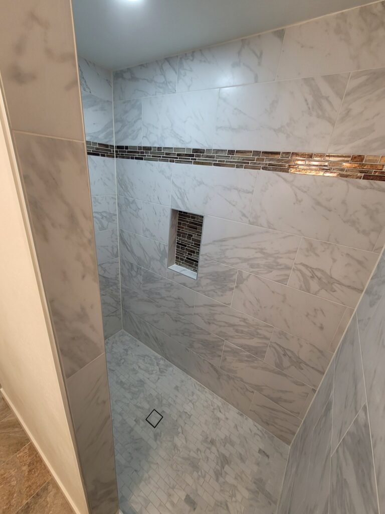 Tiled shower surround with a decorative accent band