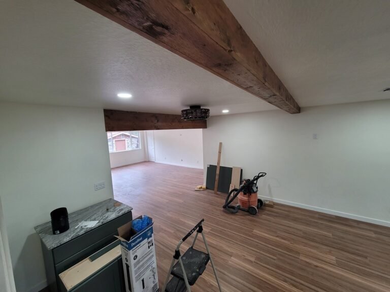Open interior with a wood beam and flooring, work in progress