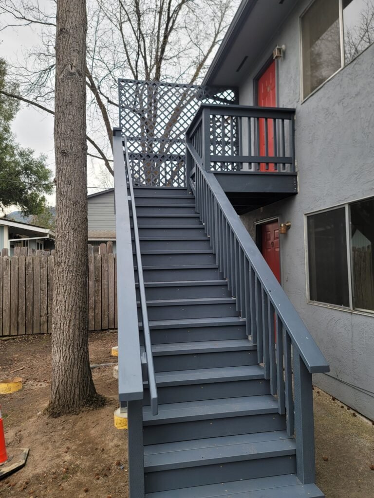 Gray exterior stairs leading to an upper landing