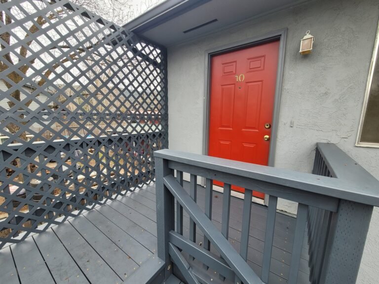 Gray deck landing beside a red entry door