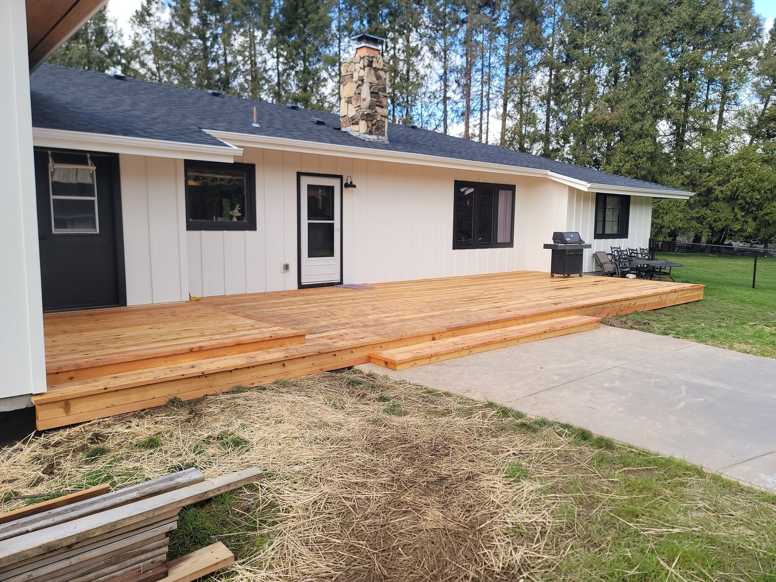 Long wood deck and steps across the front of a house
