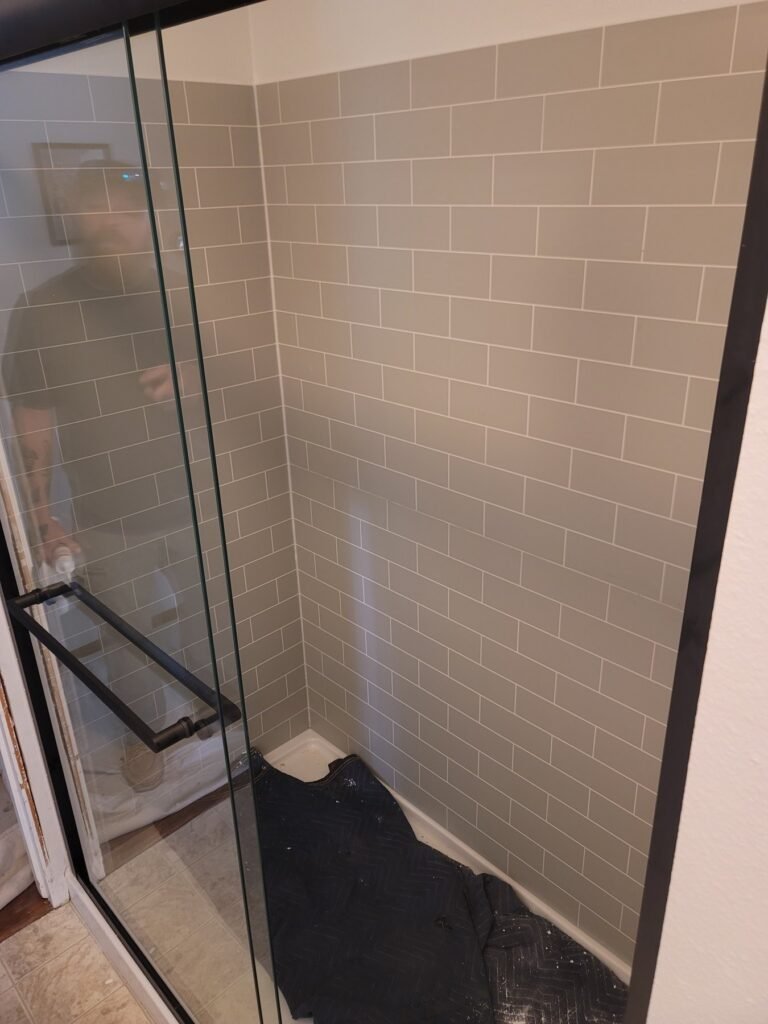 Subway shower tile and black-framed glass enclosure