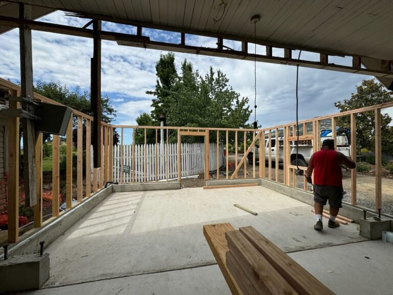 Wall framing and a concrete floor beneath a roof